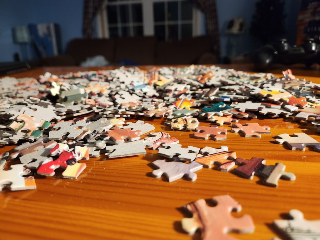 unsorted puzzle pieces on a table 