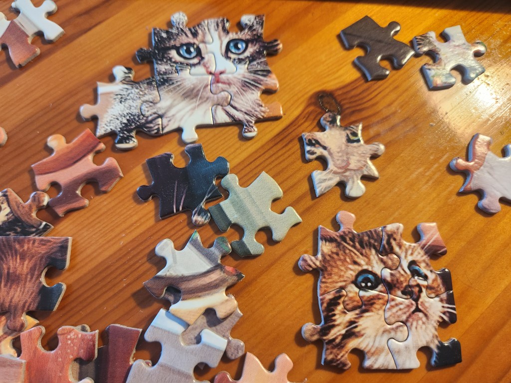 Puzzle pieces showing two cats' faces