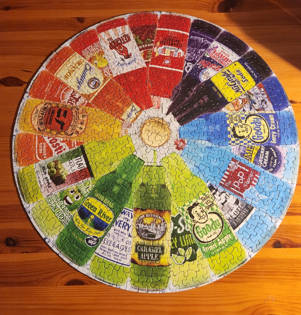 Finished round puzzle (500 pieces) showing soda in glass bottles arranged by color.