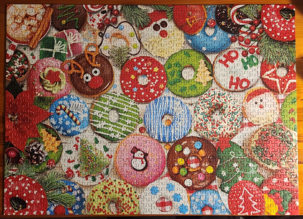 Completed jigsaw puzzle showing a variety of Christmas themed doughnuts